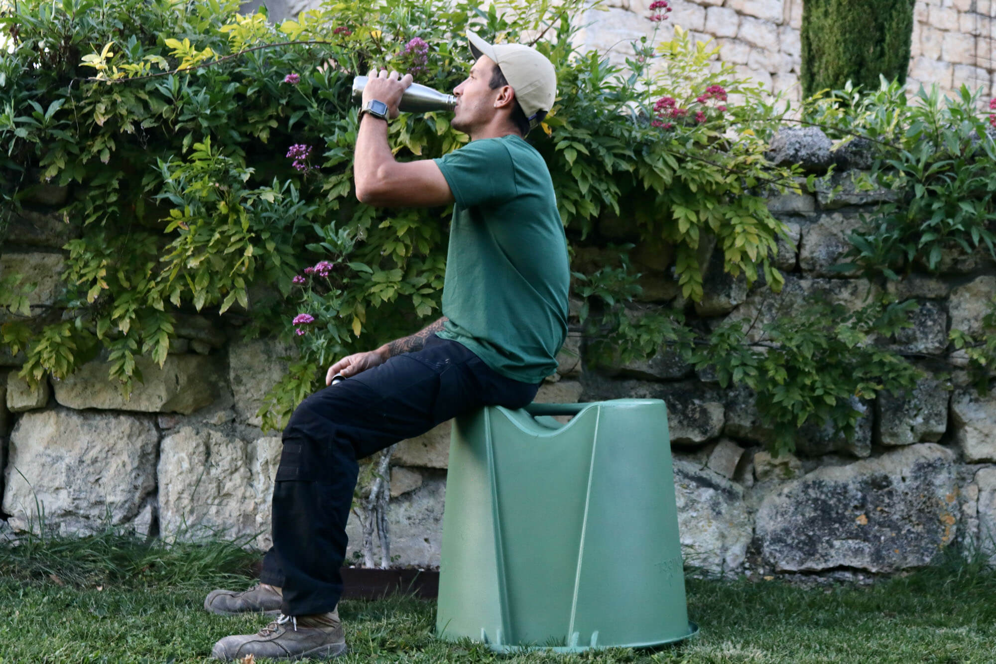 jardinier paysagiste assis sur la poubelle de déchets verts GreenCollect
